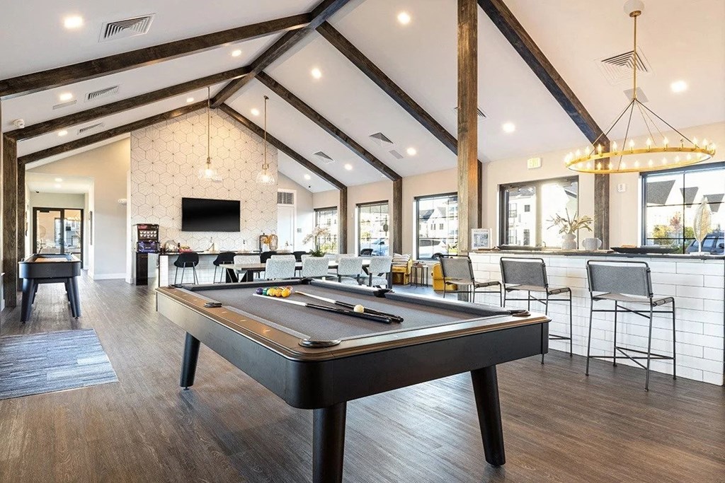 a game room with a pool table and a bar