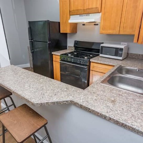 A kitchen with granite countertops and wooden cabinets.
