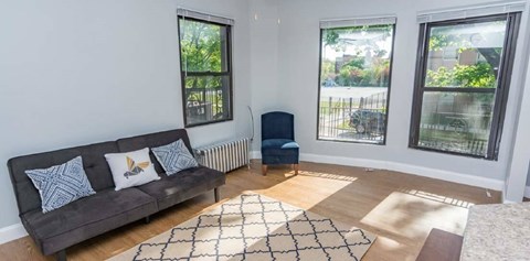 A living room with a grey couch and a blue chair.