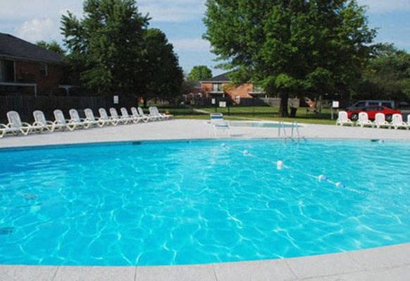 a large swimming pool with white chairs around it