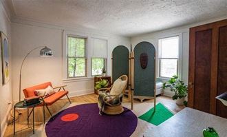 a living room filled with furniture and a purple rug