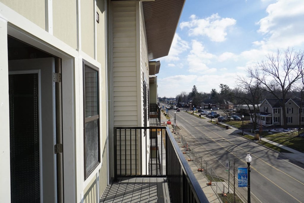 a balcony with a view of a street and a house