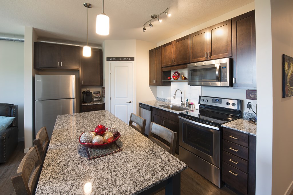 A kitchen with granite countertops and stainless steel appliances.