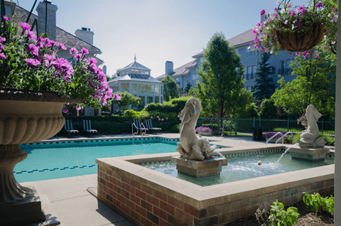 Outdoor pool with fountain sculptures and landscaping at Regents Club of Troy Apartments, Troy, MI 48084