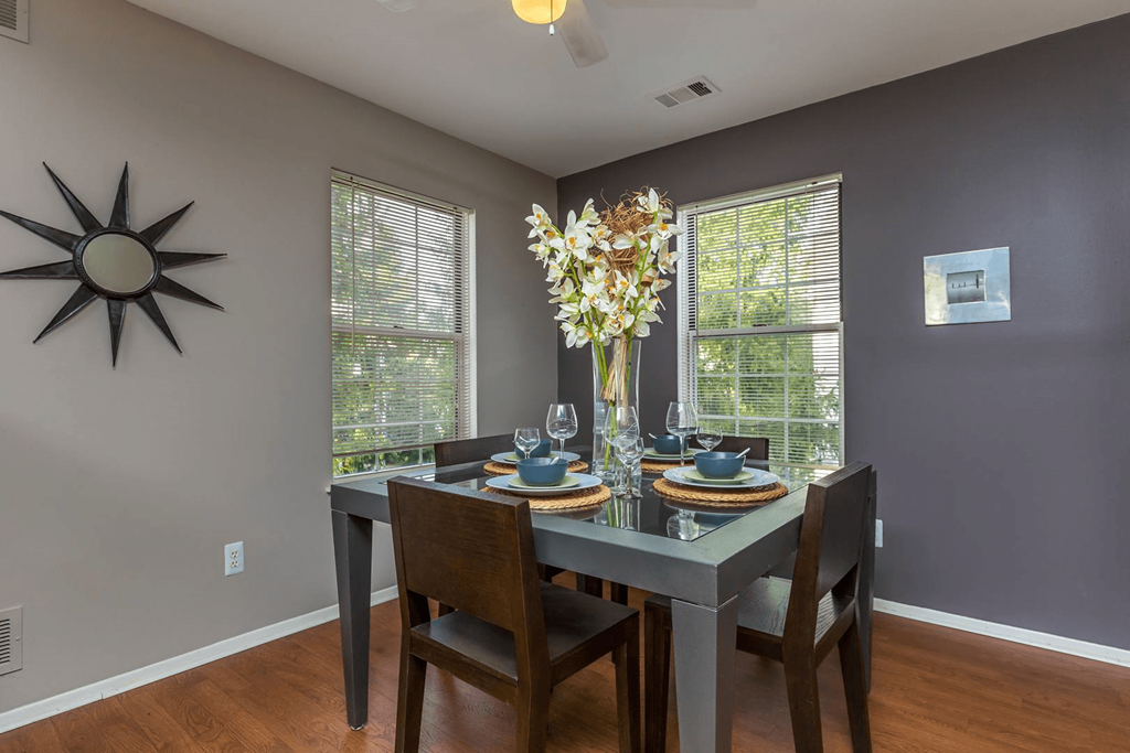 a dining room with a table and chairs and a window at Village Club of Farmington Hills, Farmington Hills
