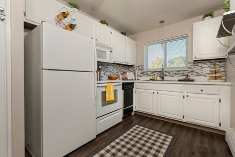 a kitchen with white cabinets and a refrigerator