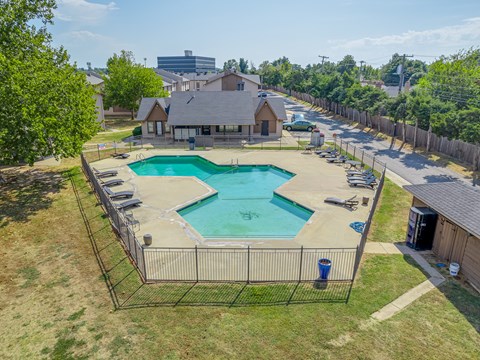 A residential area with a swimming pool and a fenced yard.