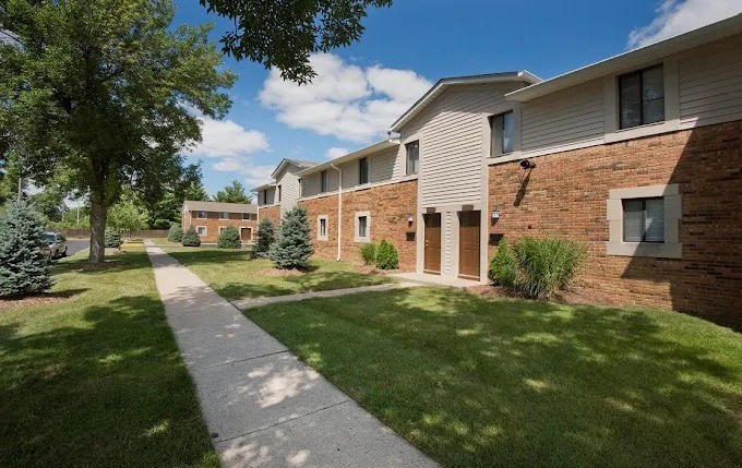 A long concrete walkway leads to a row of houses.