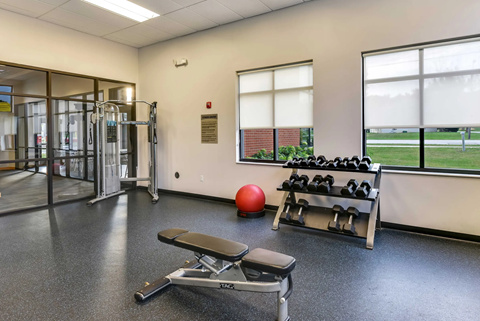 A gym with a red ball and a bench.