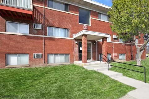 A red brick building with a black railing in front.