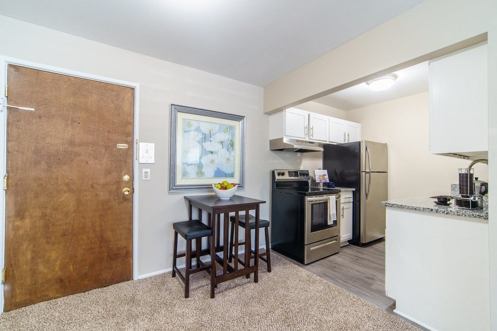 Eating area with beige carpeting and updated kitchen.