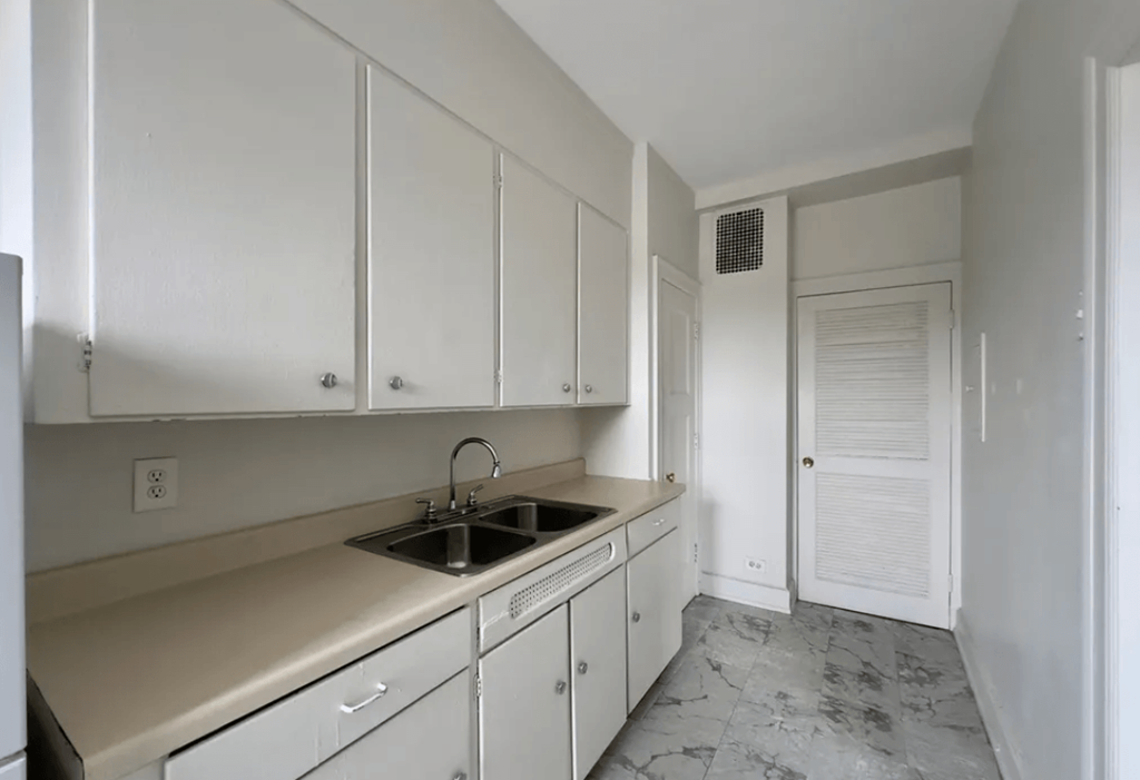 a kitchen with white cabinets and a sink