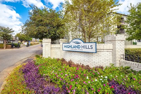 The entrance to Highland Hills is marked by a sign and a flower bed.