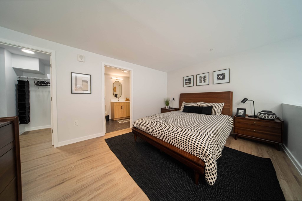 a bedroom with a bed and a dresser and a bathroom