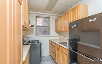 a kitchen with wood cabinets and black appliances