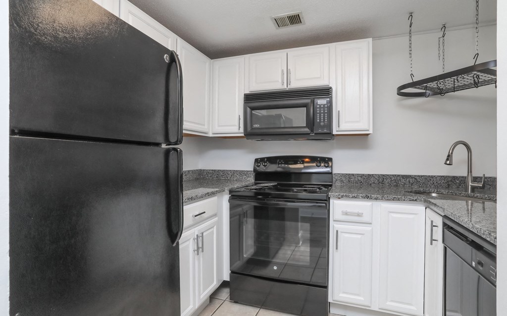 a kitchen with black appliances and white cabinets