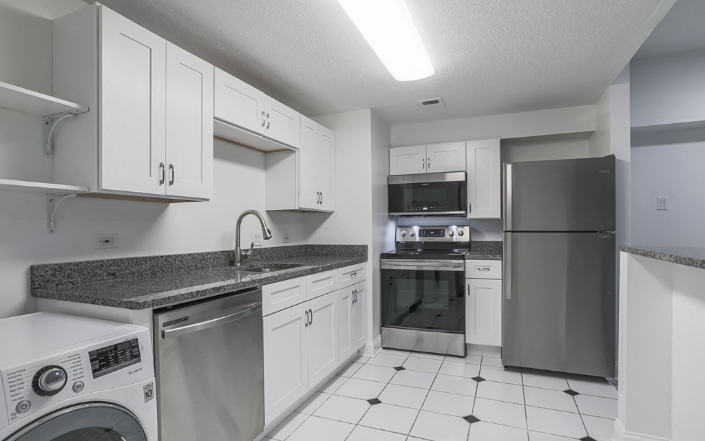 a kitchen with white cabinets and stainless steel appliances