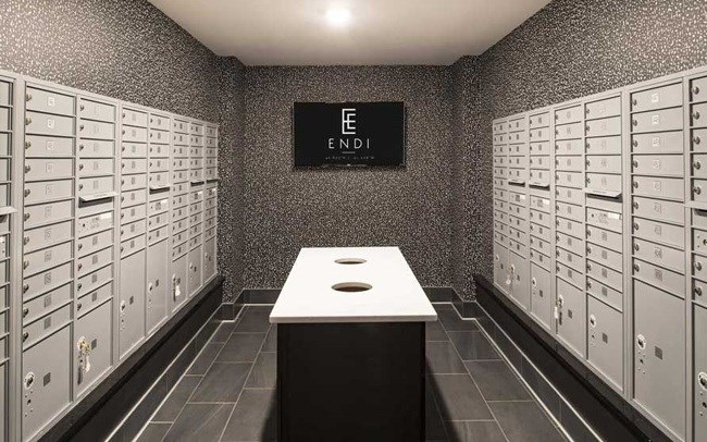 A room with a long table in the middle and a wall of mailboxes on either side.