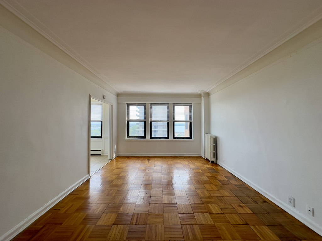 an empty living room with wooden floors and a window