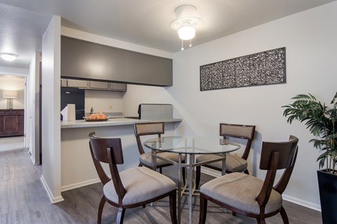 A dining room with a glass table and chairs.