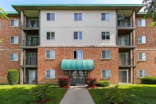 an apartment building with a green awning