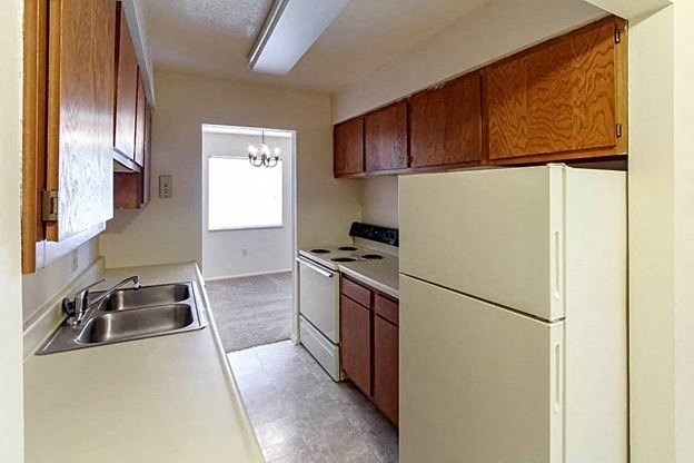 a kitchen with a white refrigerator freezer next to a stove top oven