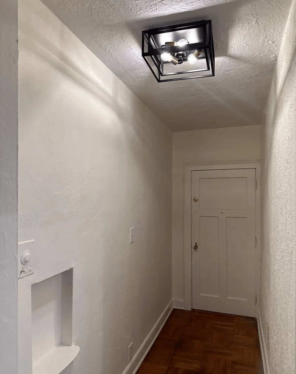 a small hallway with a small window and a small white door