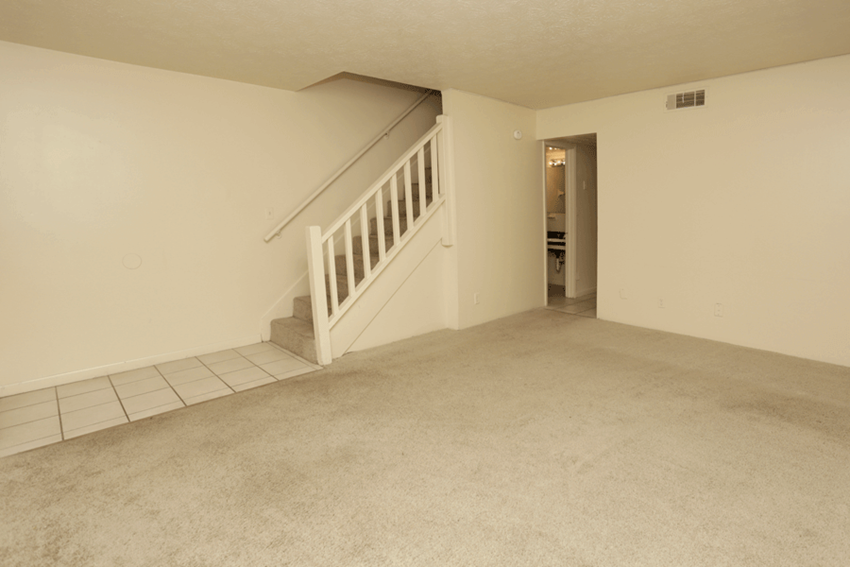 Carpeted living room with stairs