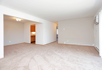 Living room and dining room with tan carpeting and white walls. - Photo Gallery 3