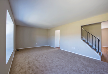 Living room with plush carpeting and stairs - Photo Gallery 4