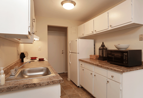 a kitchen with white cabinets and a sink and a refrigerator