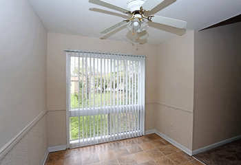 Dining room with white celling fan, door-wall with blinds, and brown tile floors. - Photo Gallery 2