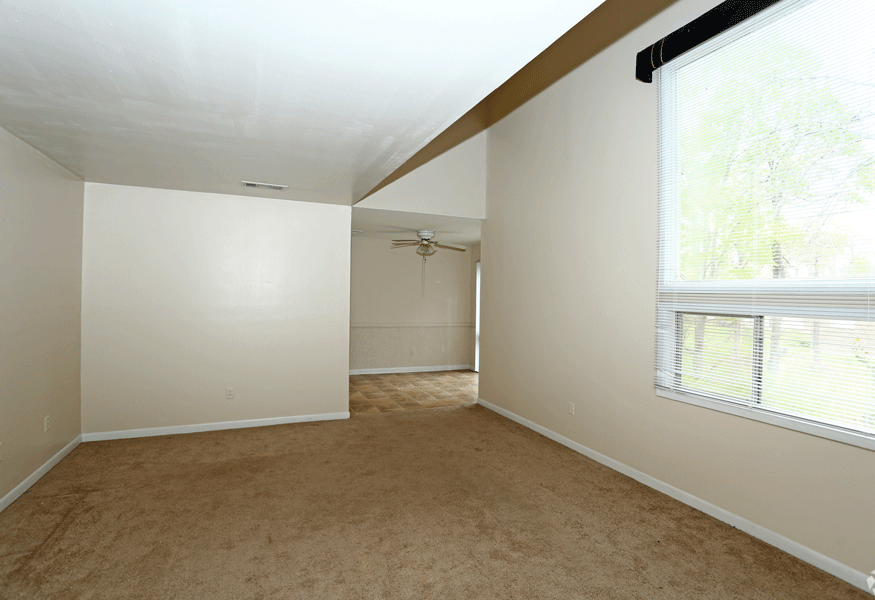 Living room with tan carpet and light almost white walls.