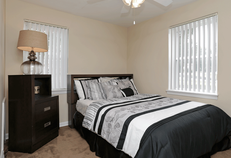 Black and white bedspread next to dresser