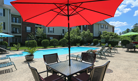our apartments have a pool and a table with a red umbrella