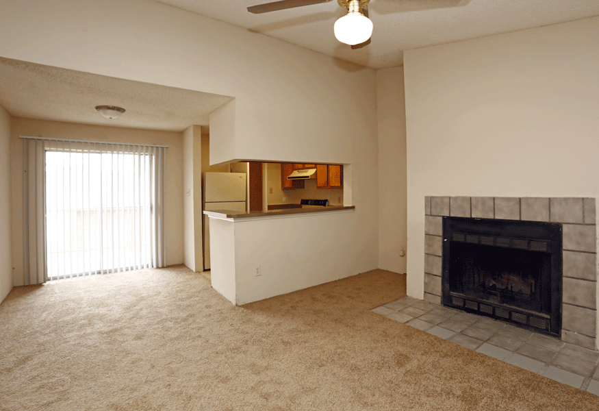 an empty living room with a fireplace and a window