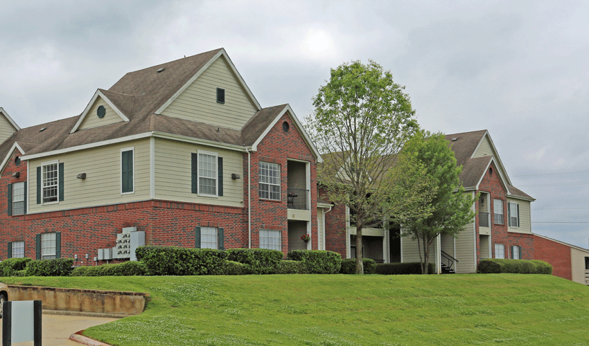Exterior of University Hill with landscaping and green grass.