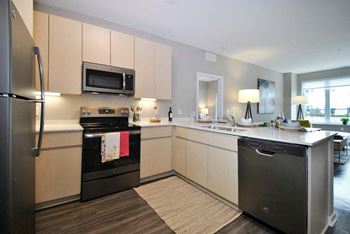 a kitchen with a stove top oven next to a sink at The George, Ann Arbor, MI