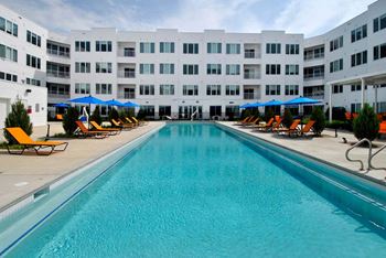 a large swimming pool with a white building in the background at The George, Ann Arbor, 48104