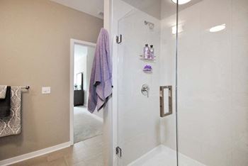 a bathroom with a glass shower door and a purple towel