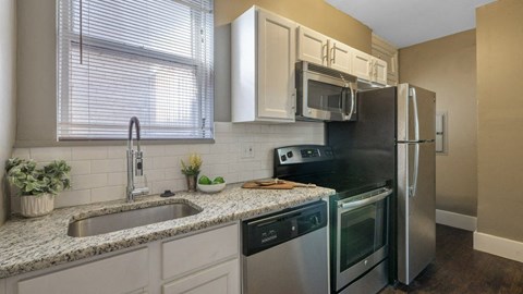 A kitchen with a sink, stove, and refrigerator.