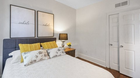 a bedroom with a bed and two paintings on the wall