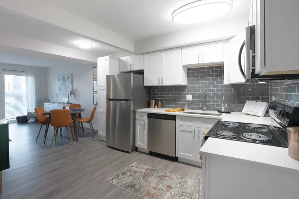 A modern kitchen with a dining table and chairs.