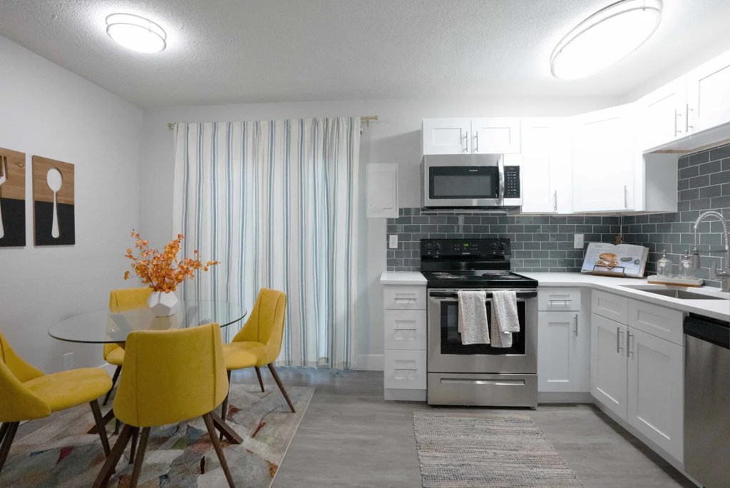 A kitchen with a yellow table and chairs.