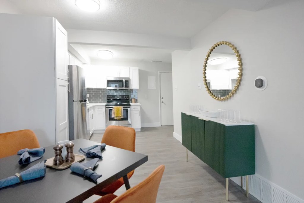A modern kitchen with a dining table set for two.