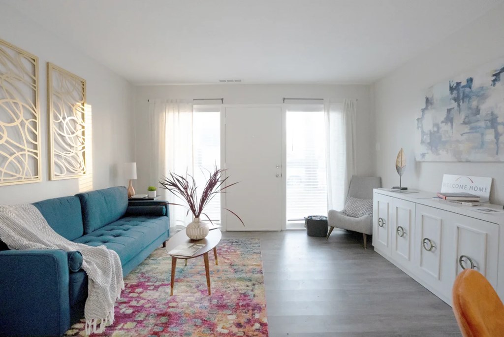 A living room with a blue couch and a white cabinet.