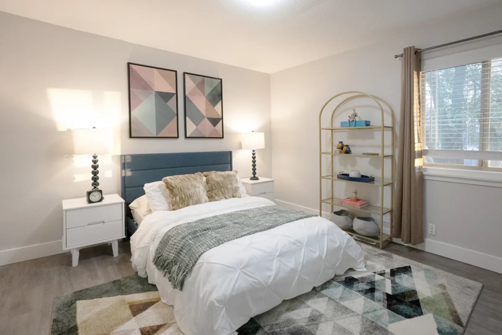 A bedroom with a large bed and a shelf with shoes on it.