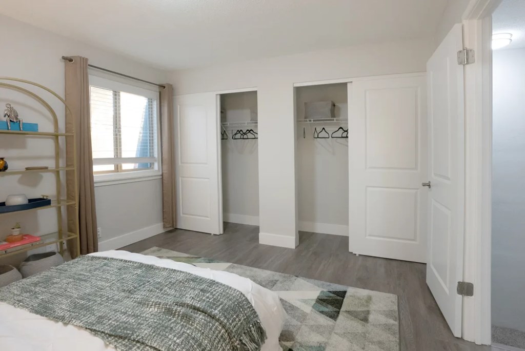 A bedroom with a bed, a wardrobe, and a shelf.