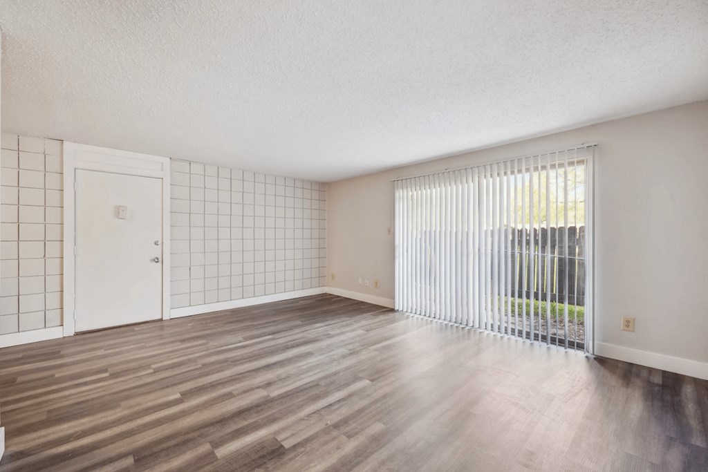 A room with wooden flooring and a white door.