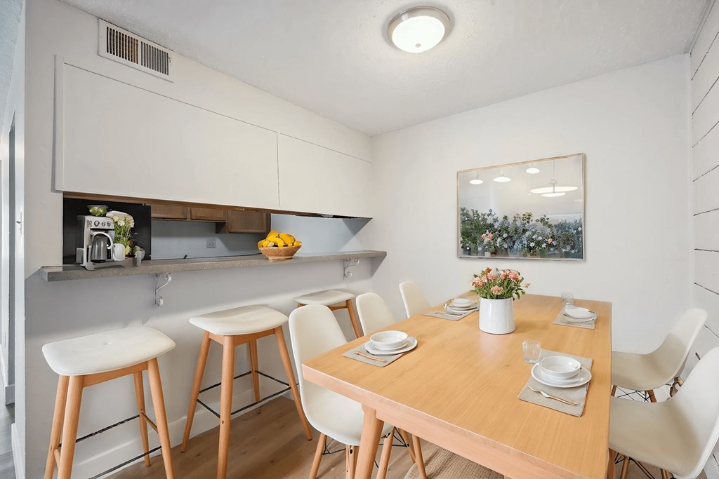 A kitchen with a table and chairs.